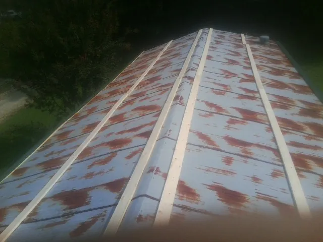 Rusted metal roof panels with new wood purlins before replacement — Storm Damage Roof Repair in Jersey Shore by Roofing Brothers