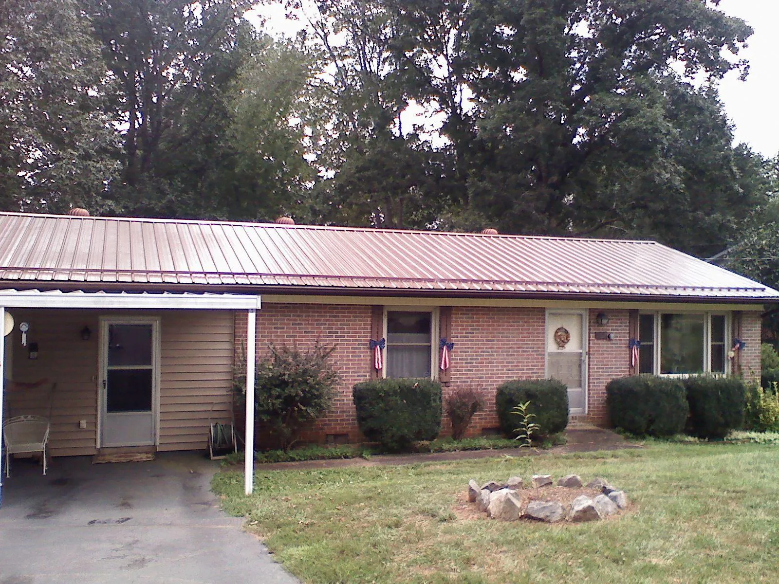 Bronze metal roof and carport on a brick ranch home — Roof Repair work by our crew in Jersey Shore